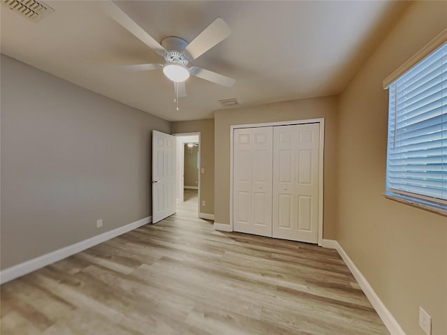 unfurnished bedroom with light hardwood / wood-style floors, a closet, and ceiling fan