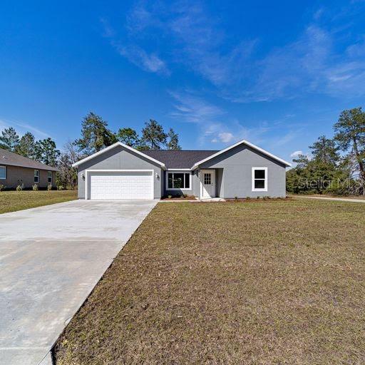 ranch-style house featuring a garage and a front yard