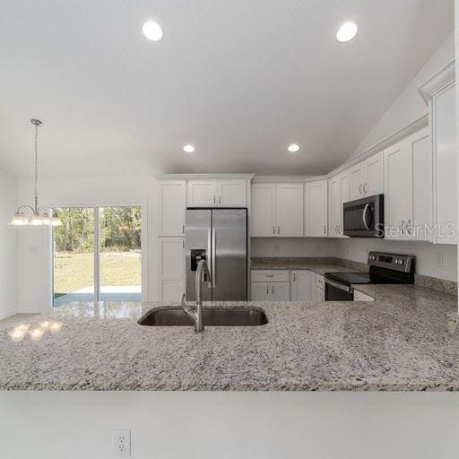 kitchen with hanging light fixtures, sink, kitchen peninsula, appliances with stainless steel finishes, and white cabinetry