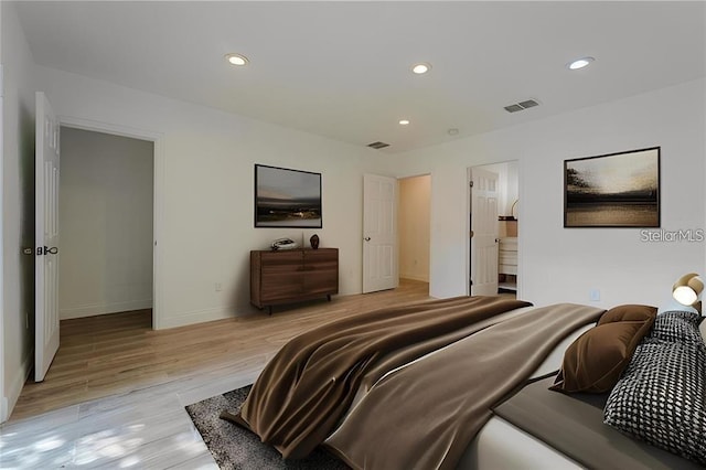 bedroom featuring ensuite bathroom and light hardwood / wood-style floors