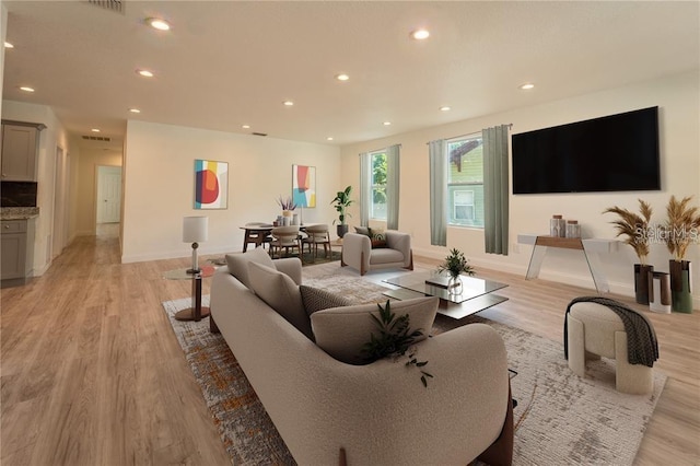 living room with light wood-style floors, recessed lighting, visible vents, and baseboards