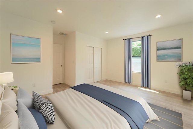 bedroom featuring visible vents, baseboards, light wood-style floors, a closet, and recessed lighting