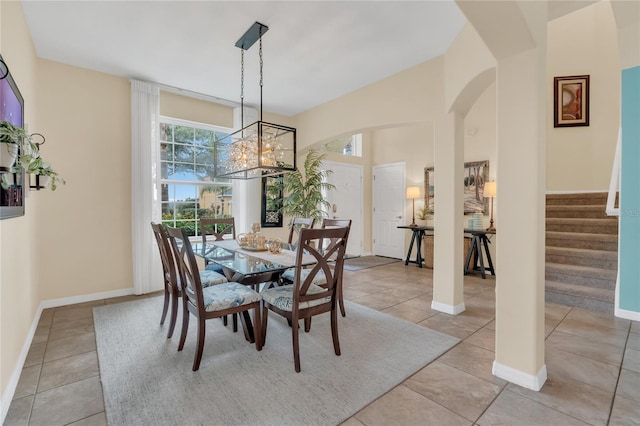 tiled dining room featuring an inviting chandelier