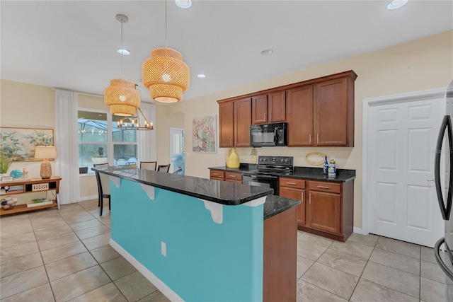 kitchen featuring light tile patterned floors, a kitchen island, pendant lighting, dark stone counters, and black appliances