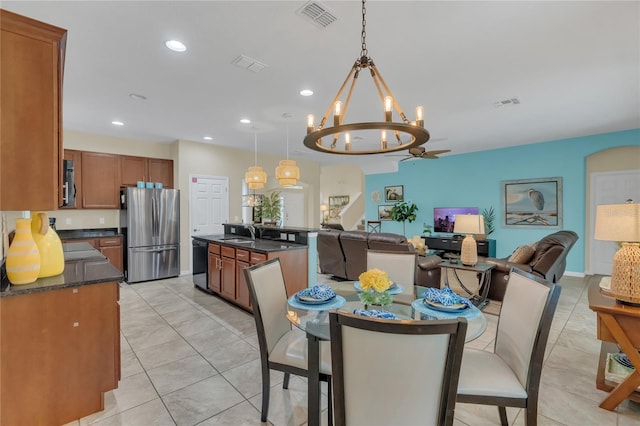 tiled dining room featuring a chandelier and sink