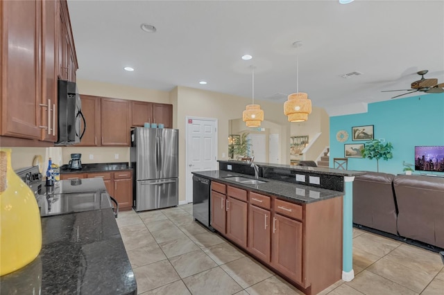 kitchen featuring pendant lighting, sink, a kitchen island with sink, light tile patterned floors, and stainless steel appliances