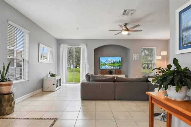 tiled living room with a textured ceiling and ceiling fan