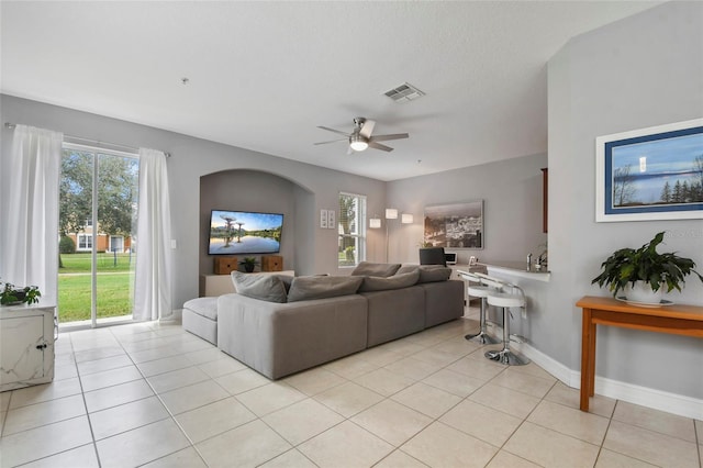 tiled living room featuring a textured ceiling and ceiling fan