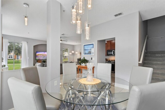 tiled dining space featuring a wealth of natural light and ceiling fan