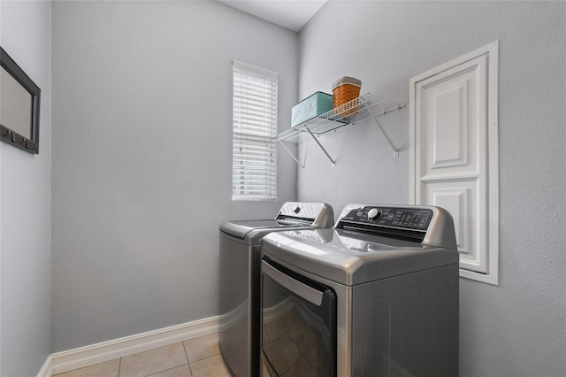 washroom with light tile patterned floors and washer and dryer