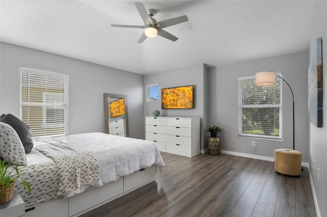 bedroom featuring a textured ceiling, ceiling fan, and dark wood-type flooring