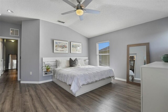 bedroom with lofted ceiling, ceiling fan, dark wood-type flooring, and a textured ceiling