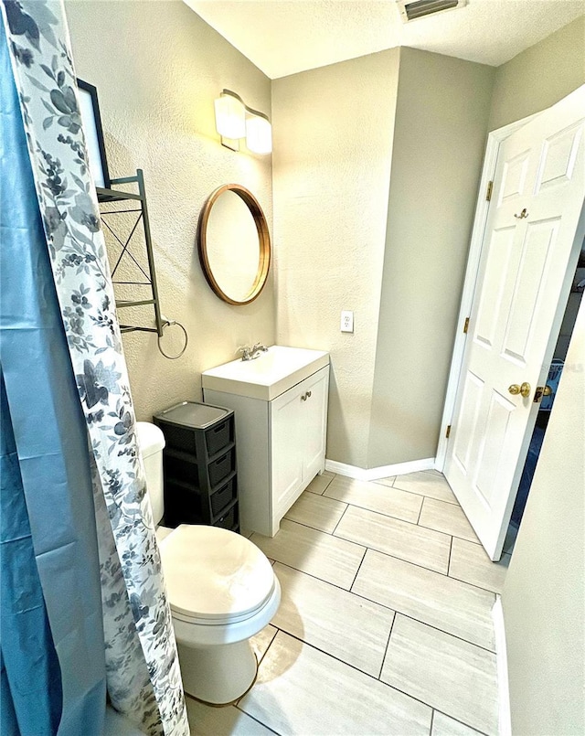 bathroom with vanity, curtained shower, and toilet