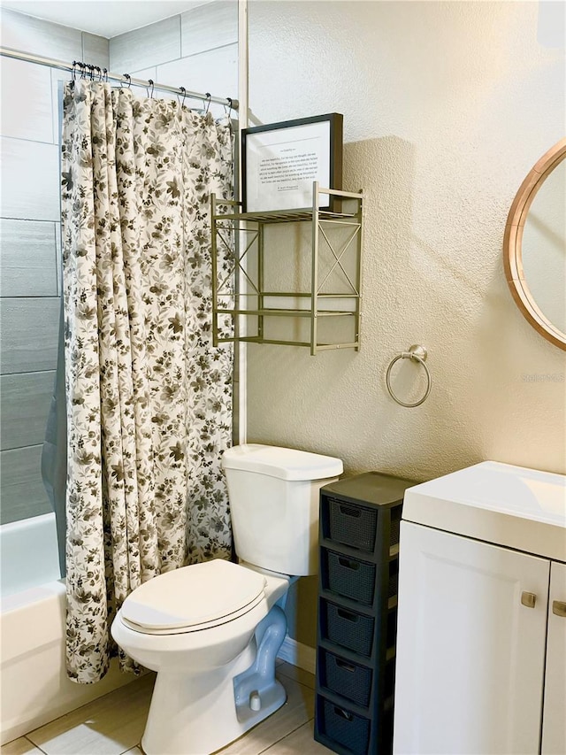 full bathroom with tile patterned flooring, shower / bath combo with shower curtain, vanity, and toilet