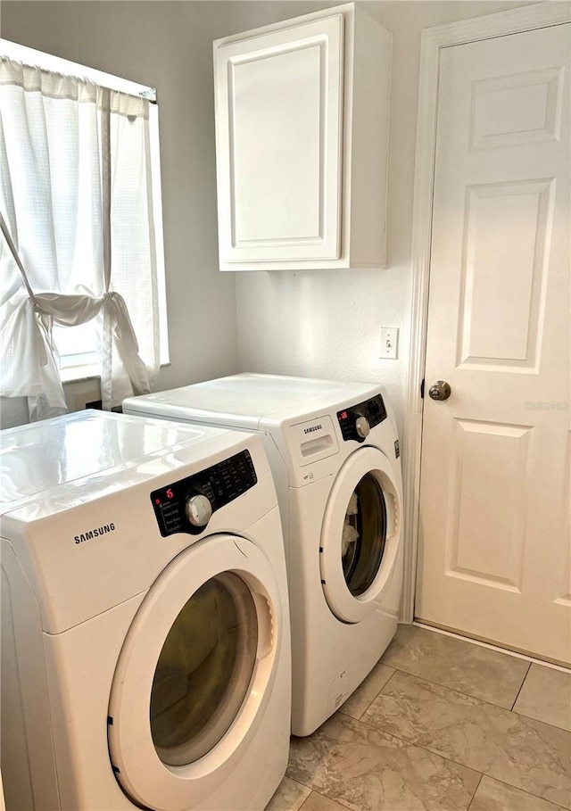 clothes washing area with cabinets and independent washer and dryer