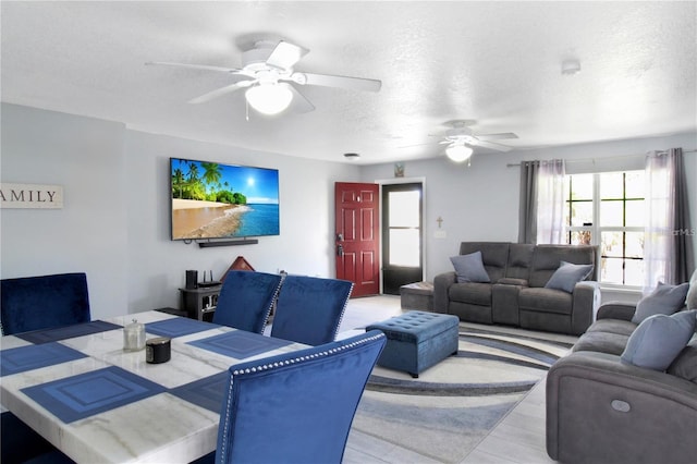 living room featuring ceiling fan and a textured ceiling