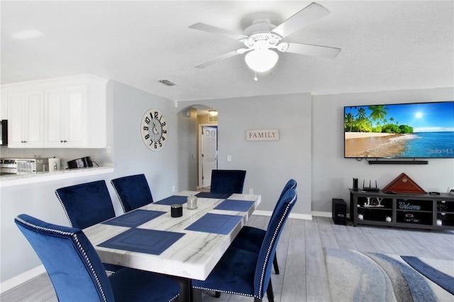 dining area with ceiling fan and light wood-type flooring