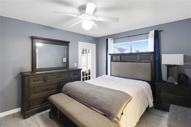 bedroom with ceiling fan, a textured ceiling, and light hardwood / wood-style flooring