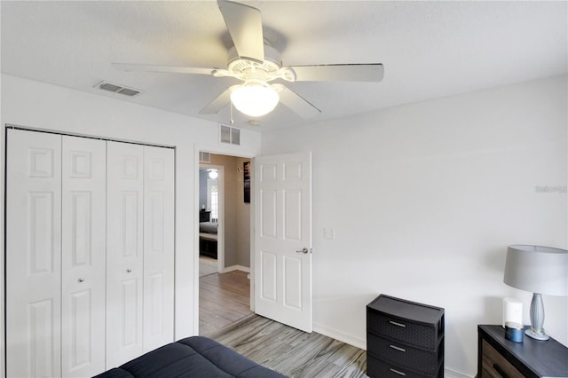 bedroom with light wood-type flooring, a closet, and ceiling fan