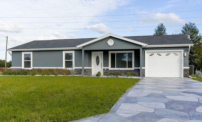 ranch-style home featuring a garage and a front lawn