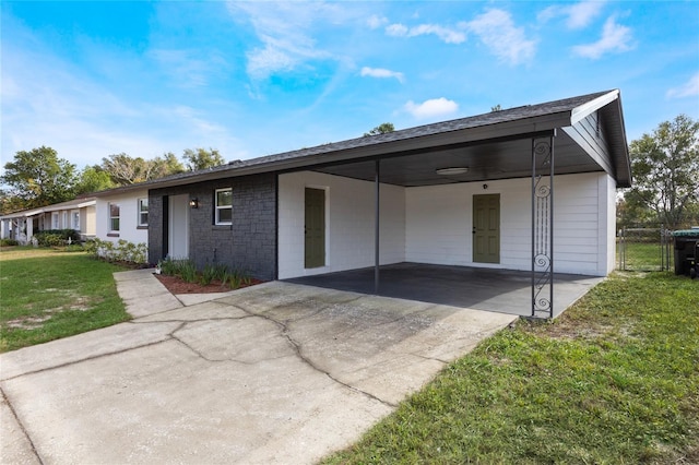 ranch-style home featuring a front lawn and a carport