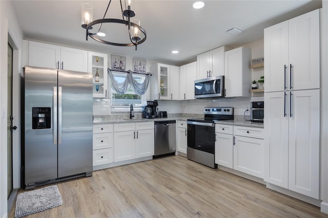 kitchen featuring light stone countertops, white cabinetry, and appliances with stainless steel finishes