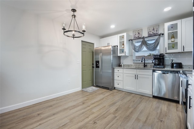 kitchen featuring white cabinets, appliances with stainless steel finishes, and an inviting chandelier