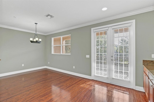 unfurnished dining area featuring dark hardwood / wood-style floors, an inviting chandelier, and ornamental molding