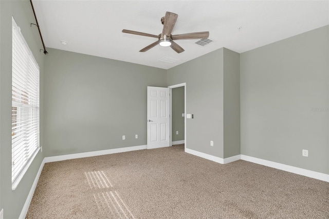 carpeted empty room with ceiling fan and a healthy amount of sunlight