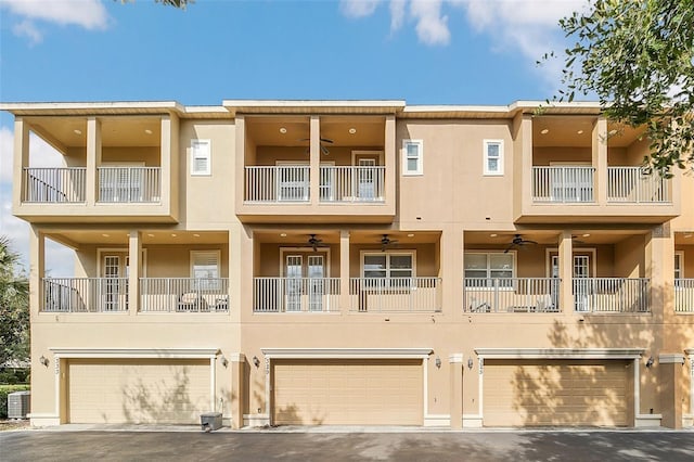 view of property with central AC, a garage, and ceiling fan