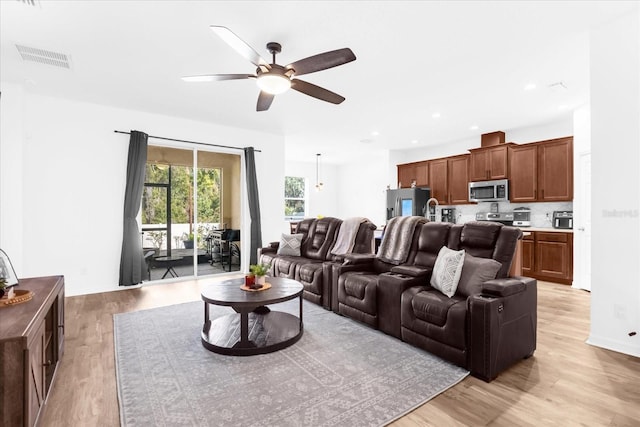 living room featuring ceiling fan and light hardwood / wood-style floors