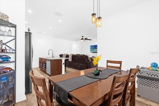 dining space featuring ceiling fan, sink, and light hardwood / wood-style flooring