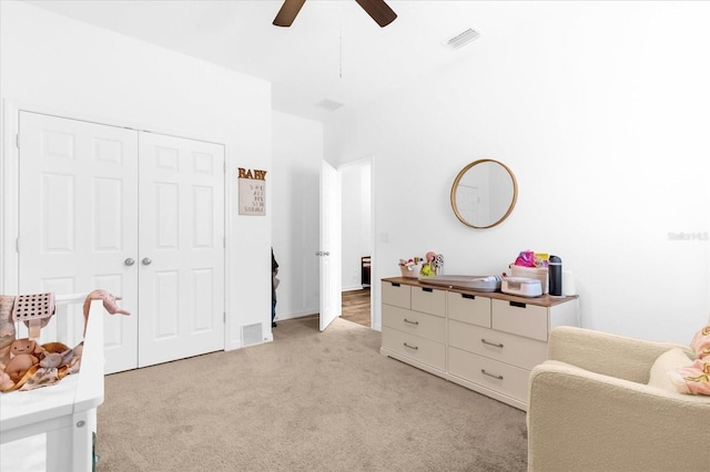 bedroom featuring ceiling fan, light colored carpet, and a closet