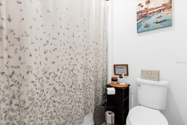 bathroom featuring a shower with shower curtain and toilet