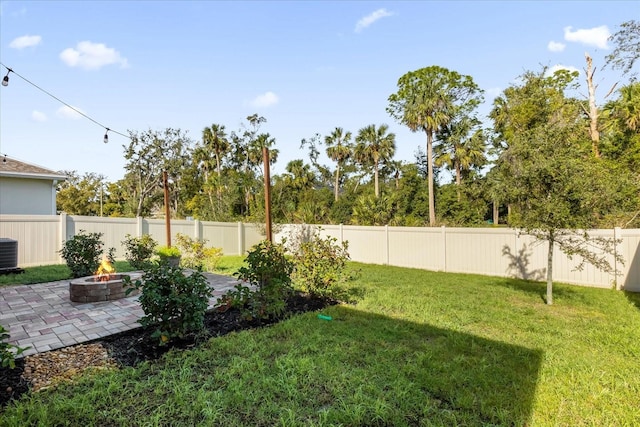 view of yard with central AC unit, an outdoor fire pit, and a patio area