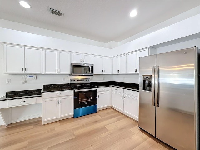 kitchen featuring white cabinets, appliances with stainless steel finishes, and light hardwood / wood-style flooring