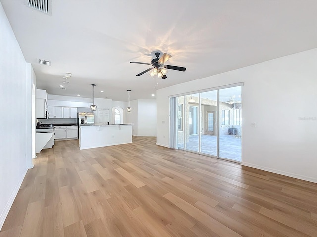 unfurnished living room with ceiling fan and light wood-type flooring