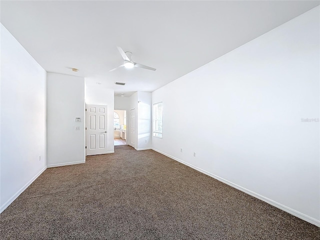 empty room featuring ceiling fan and dark carpet