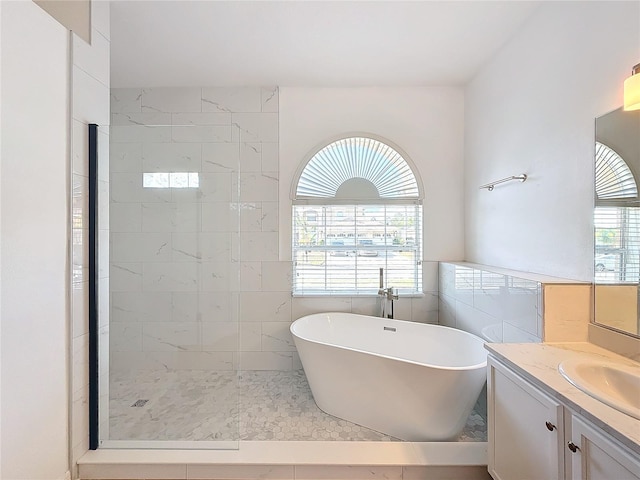 bathroom featuring tile patterned flooring, vanity, tile walls, and independent shower and bath