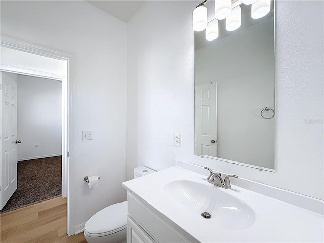 bathroom with hardwood / wood-style flooring, vanity, and toilet