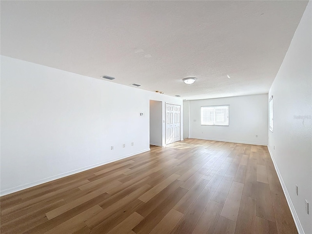 spare room featuring hardwood / wood-style floors and a textured ceiling