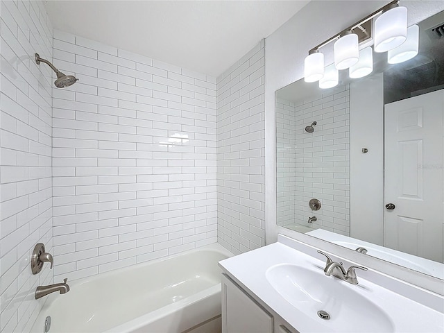 bathroom featuring vanity and tiled shower / bath