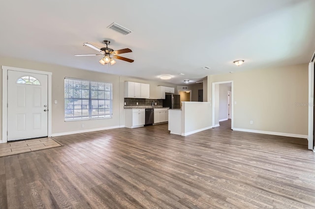 unfurnished living room featuring ceiling fan and dark wood-type flooring