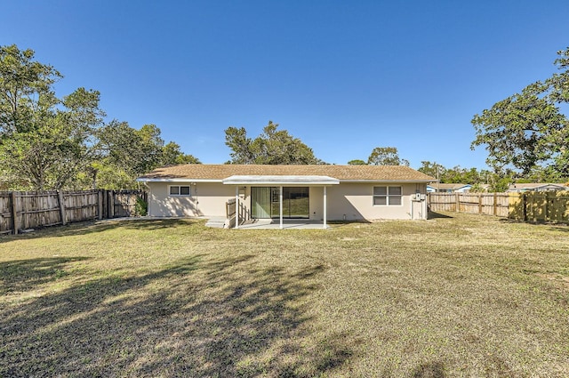 rear view of house with a lawn and a patio area