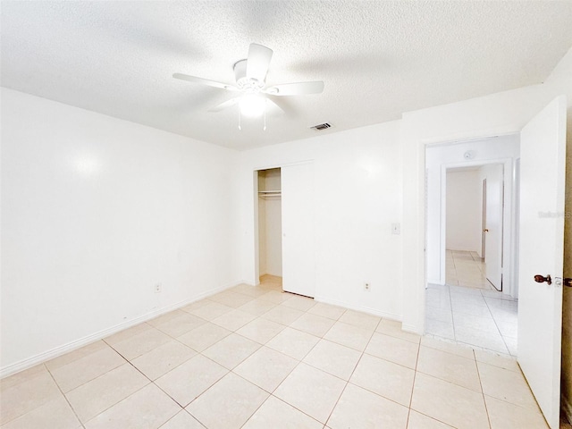 spare room with light tile patterned floors, a textured ceiling, and ceiling fan