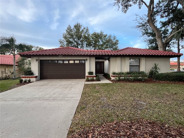 mediterranean / spanish home featuring a garage and a front lawn