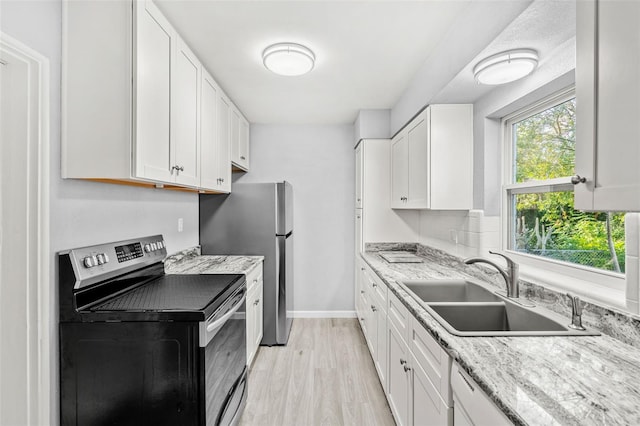 kitchen with light stone countertops, sink, white cabinetry, and stainless steel appliances