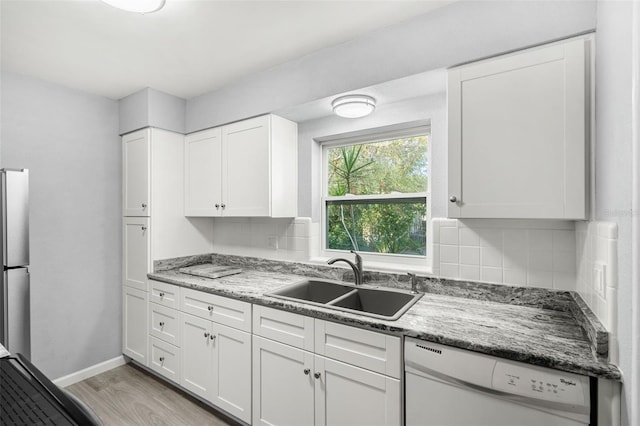 kitchen with light wood-type flooring, backsplash, sink, dishwasher, and white cabinetry