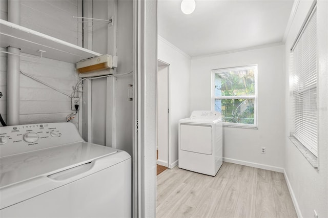 laundry room featuring light wood-type flooring, ornamental molding, and washer / clothes dryer