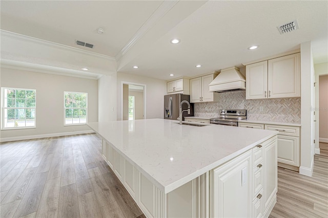 kitchen featuring a large island, ornamental molding, custom range hood, and appliances with stainless steel finishes